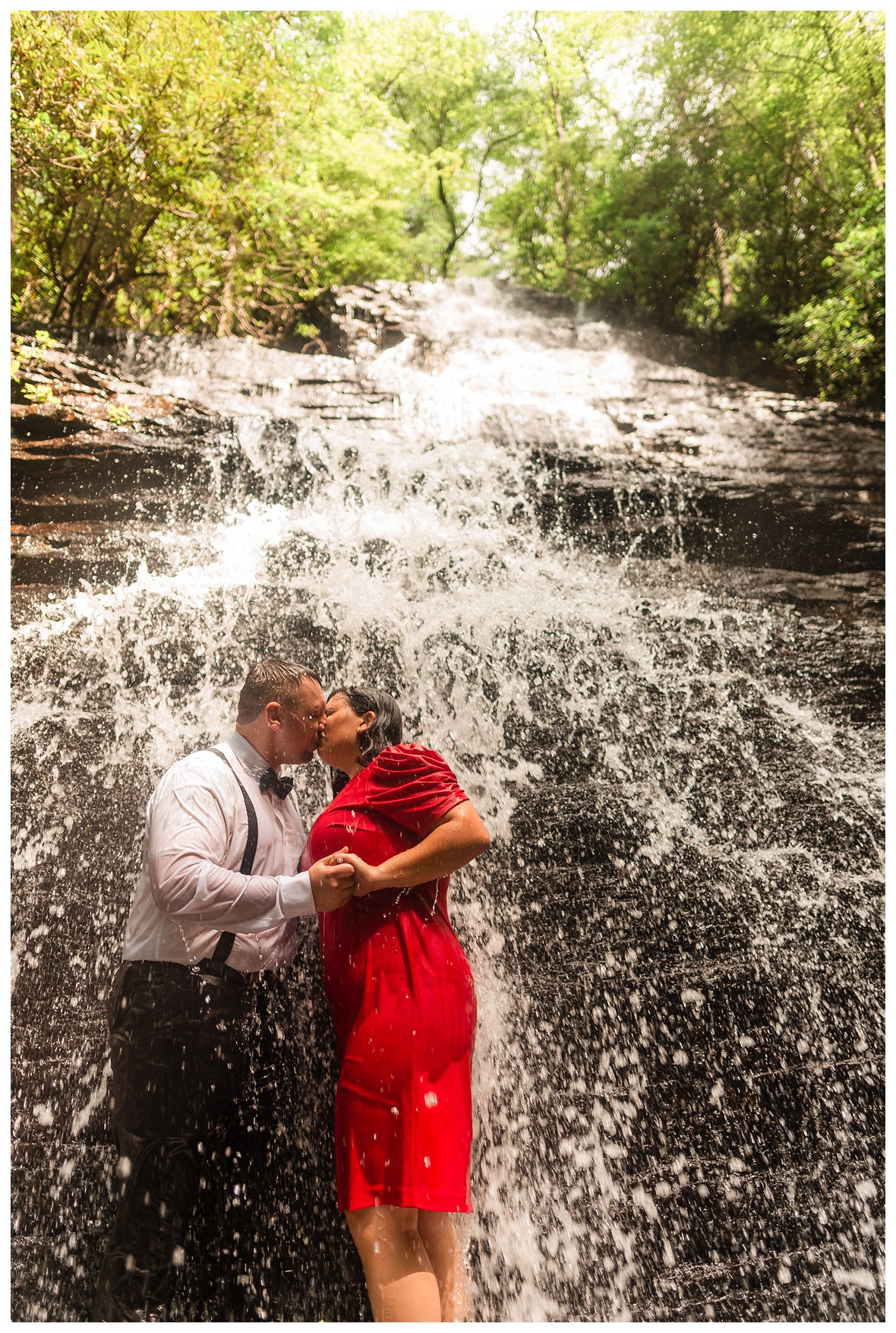 engaged couple kissing under benton falls