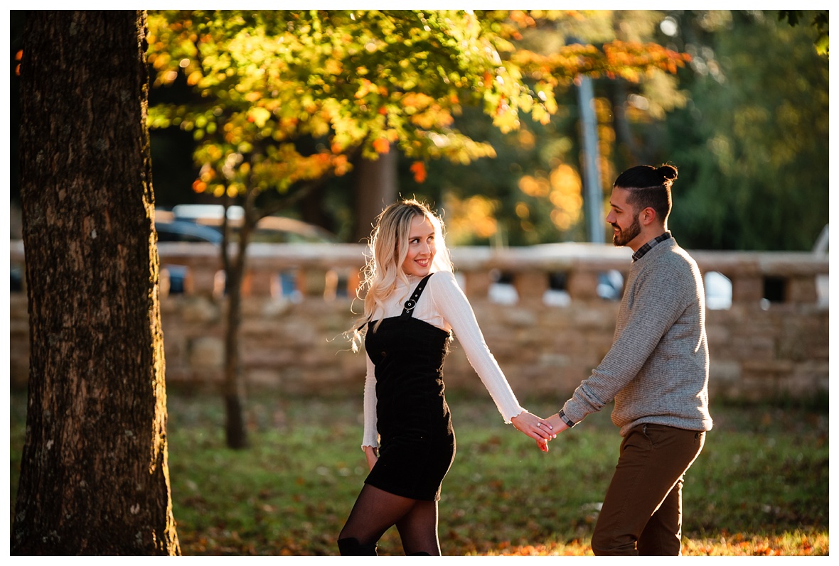 engaged couple walks through park for photos